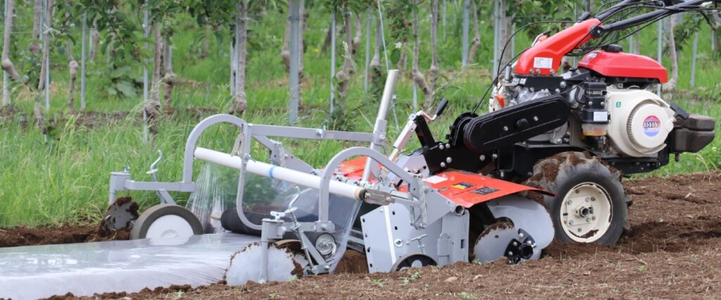 管理機でマルチングしているイメージ